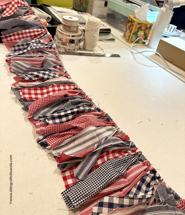 fabric garland, fabric strip garland, moda jelly roll, fabric ideas, home decor garland, make your own fabric garland, diy, gingham, 4th of july, halloween, shabby chic, wanda guess, a blog called wanda